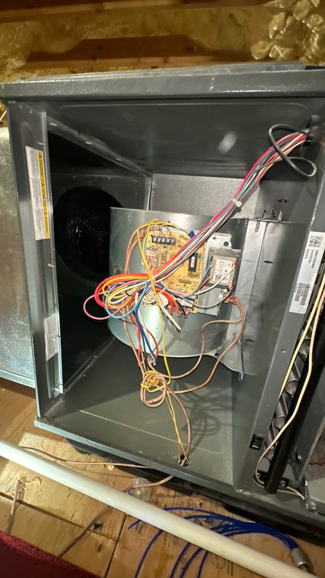 The inside of an air conditioner with a bunch of wires coming out of it.