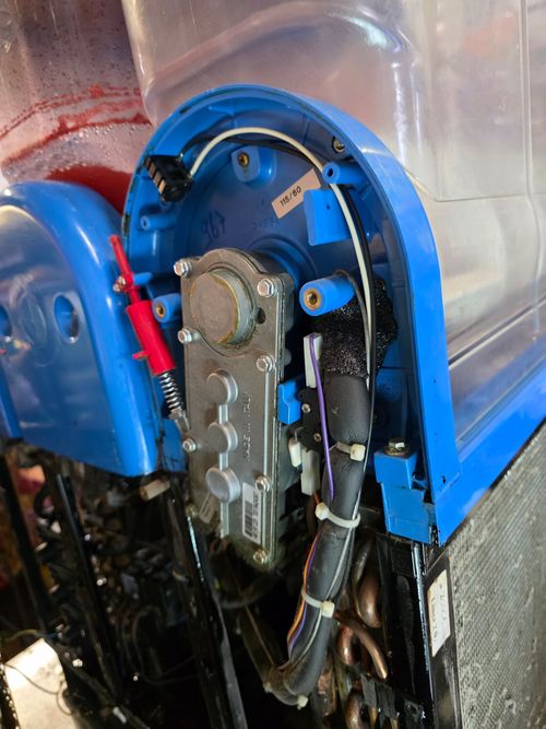A close up of a blue machine with a red button on it