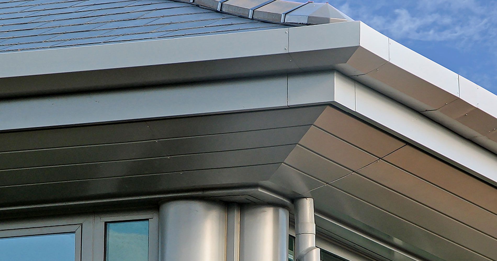 a gutter on the side of a building with trees in the background .