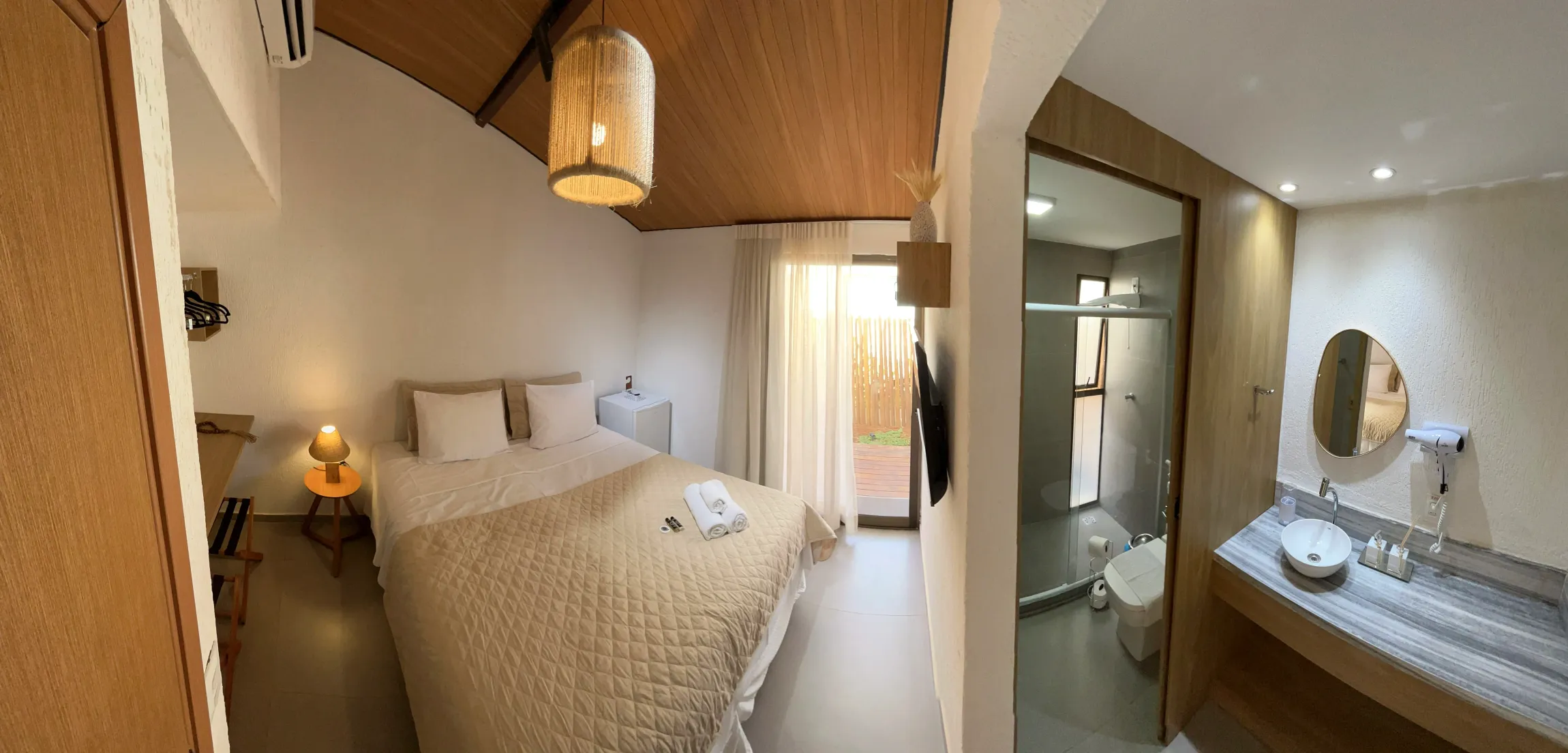 Um quarto com uma cama e um banheiro com uma pia Noronheiro Boutique & House
