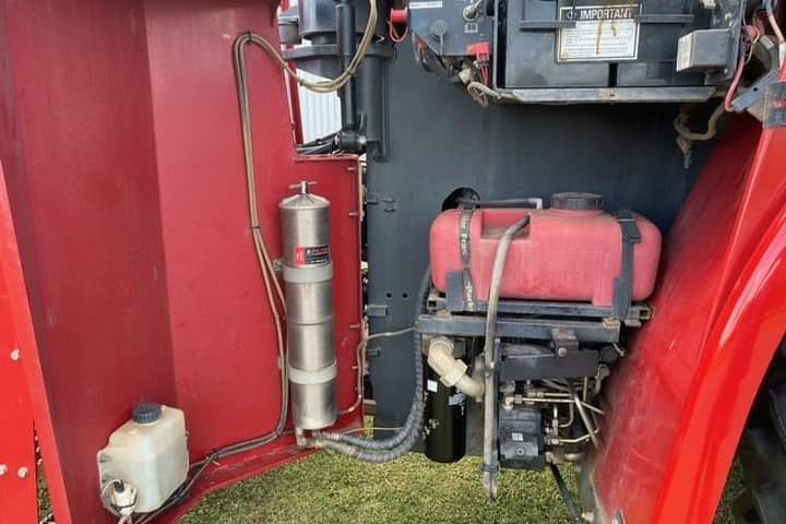 The inside of a red tractor with the hood open.
