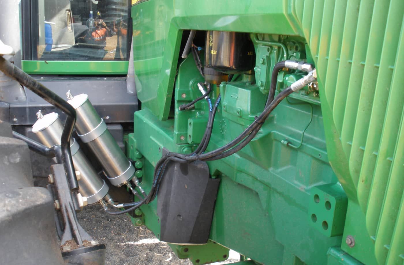 A green tractor with a hose attached to it