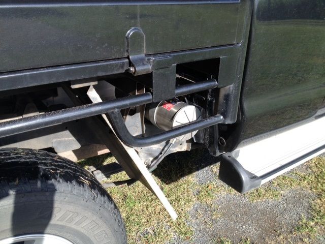 A black truck is parked in a grassy field