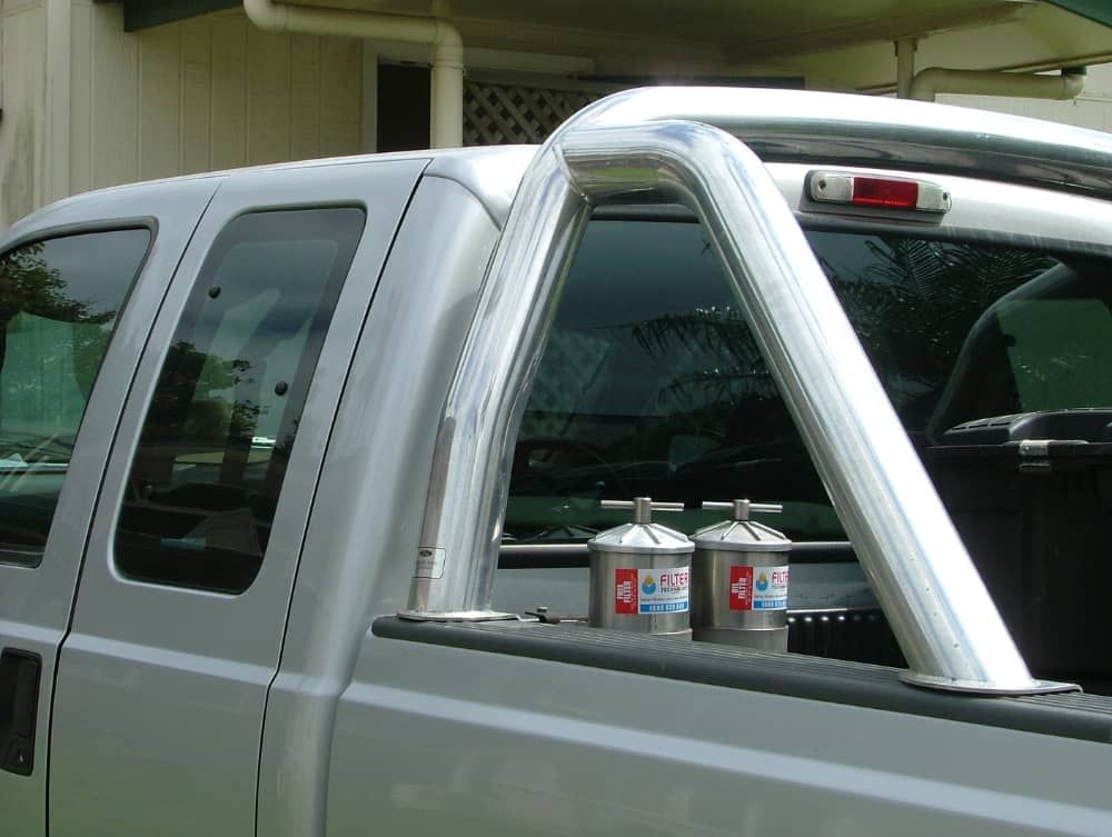 A silver truck with a stainless steel bar in the bed