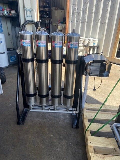 A row of stainless steel cylinders sitting on top of a metal stand.