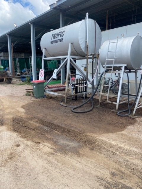 Two large tanks are sitting in front of a building.