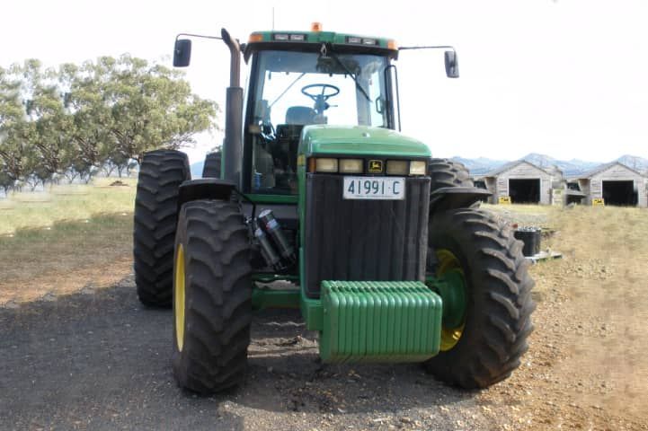 A john deere tractor is parked in a field
