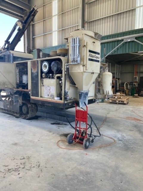 An atlas copco machine is parked in a warehouse