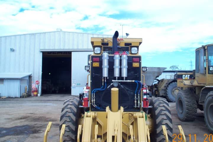 A cat tractor is parked in front of a building