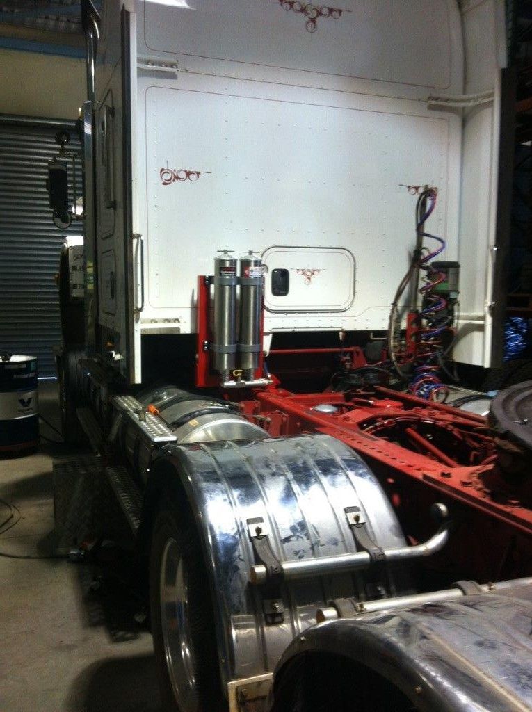 A semi truck is being worked on in a garage