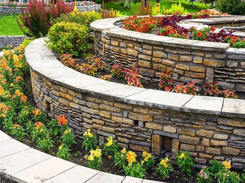 Landscaping with retaining walls and flowerbeds in residential house backyard