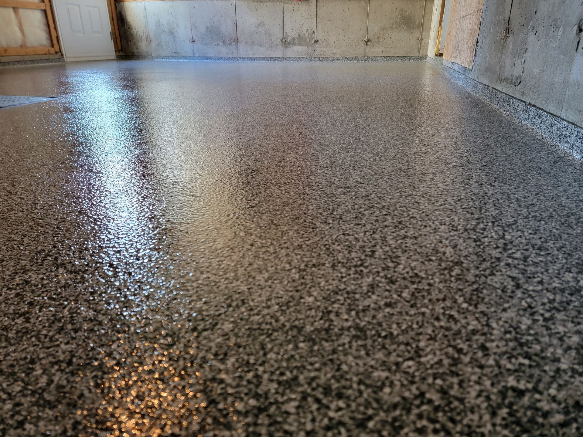 Plancher époxy gris poli et moucheté dans un sous-sol.