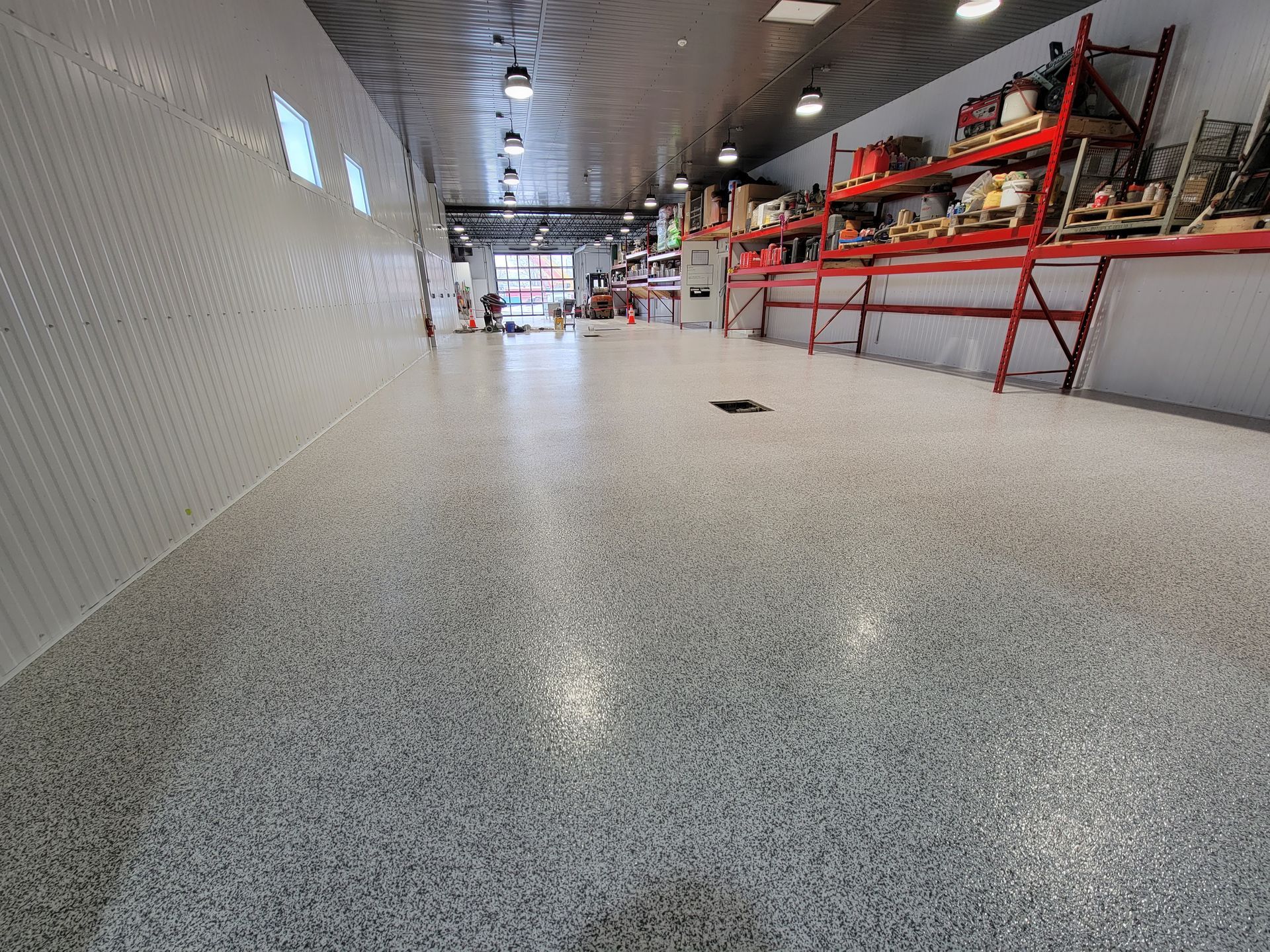 Une baignoire suspendue dans une pièce en travaux; fenêtres, sol en béton, sangles oranges retenant la baignoire.