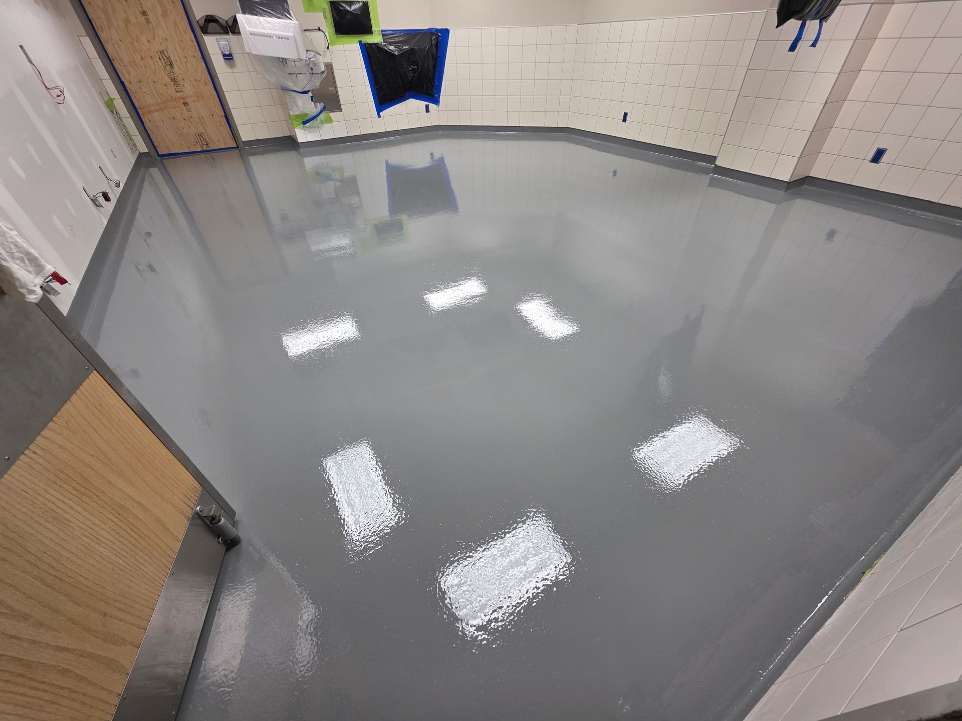 Intérieur spacieux avec cheminée en brique, poutres en bois et sol en béton.