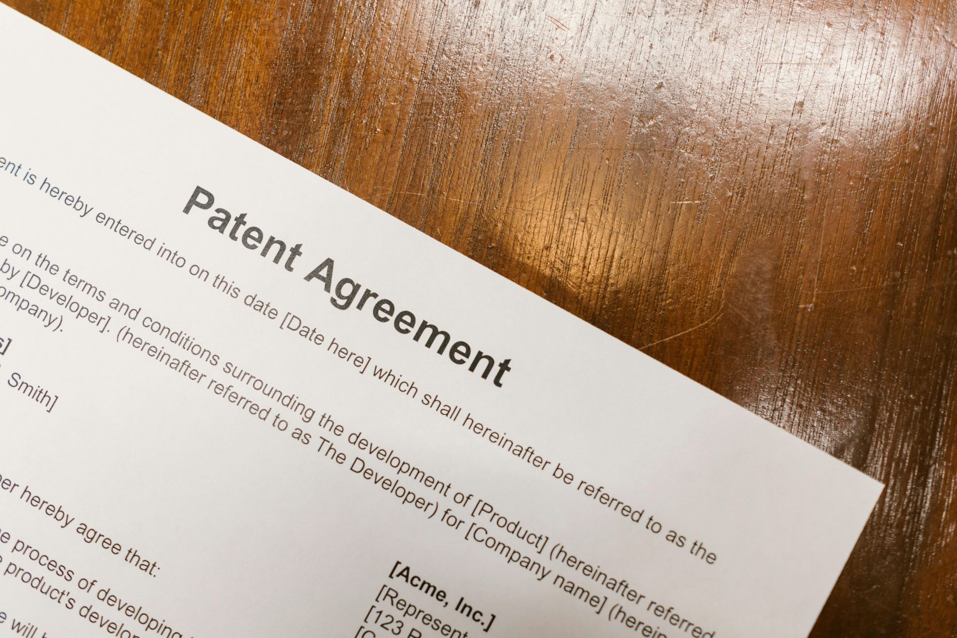 Patent Agreement document on a wooden surface.