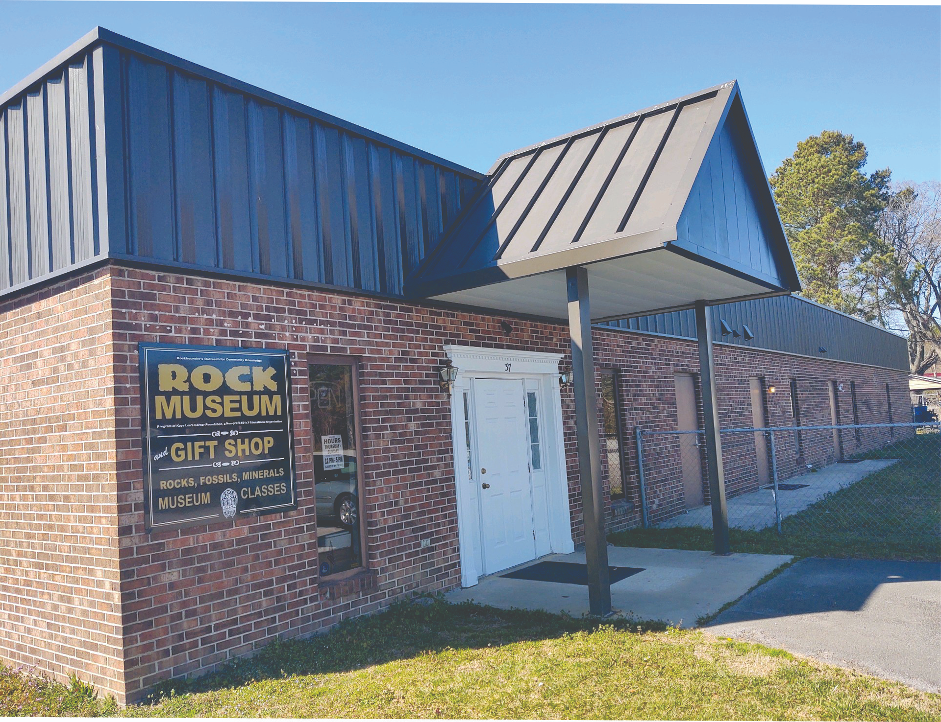 A brick building with a sign that says rock museum gift shop
