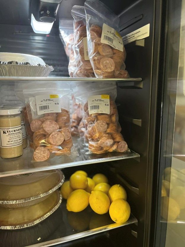 A refrigerator filled with lots of food and lemons.