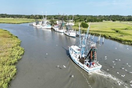 A group of boats are floating down a river.
