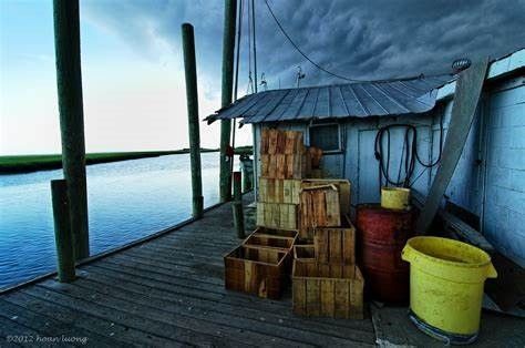 A dock filled with wooden crates and barrels next to a body of water.