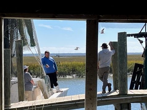 A group of people are standing on a dock next to a boat.