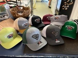 A bunch of baseball caps are sitting on a table.