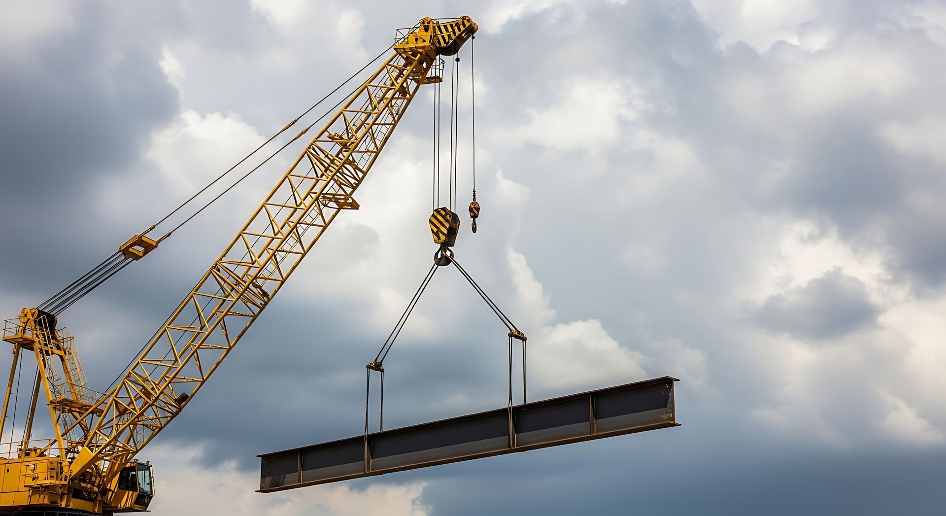 Industrial crane hook and slings during heavy machinery rigging of a structural steel beam. Industrial crane hook and slings during heavy machinery rigging of a structural steel beam.