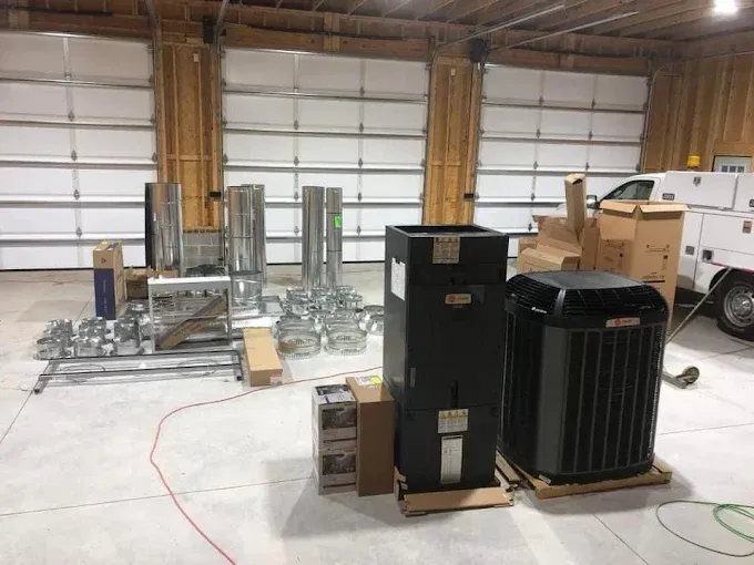 HVAC equipment and parts laid out in a warehouse, ready for installation.