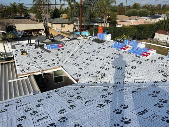 An aerial view of a roof with a shadow of a person on it.