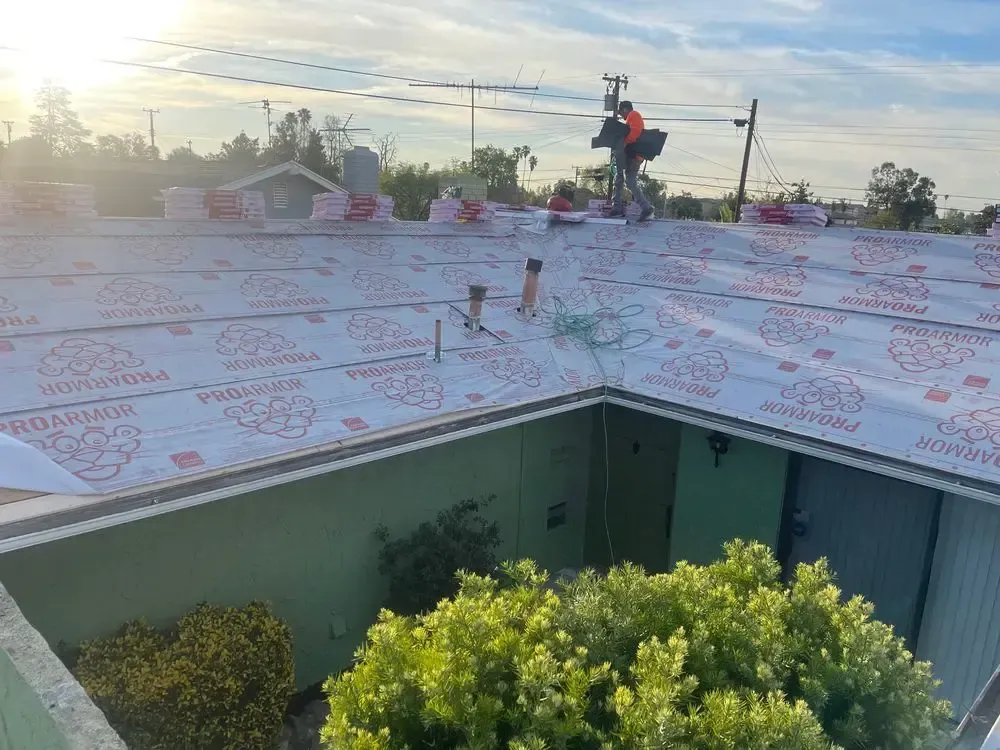 A man is working on the roof of a house.