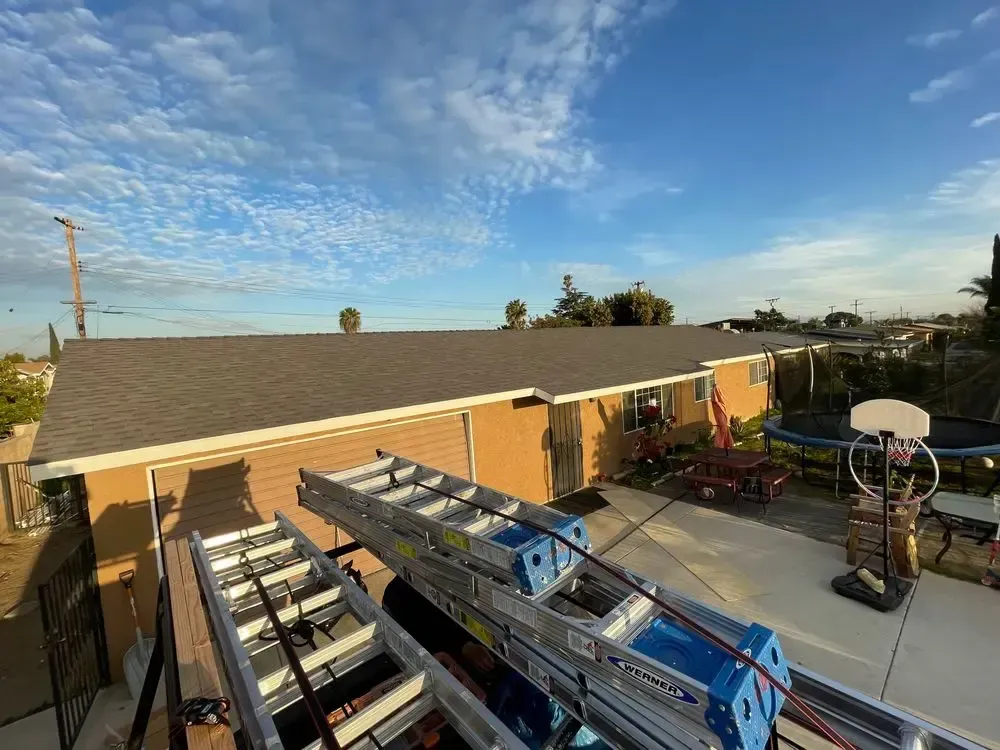 A ladder is sitting on the roof of a house.