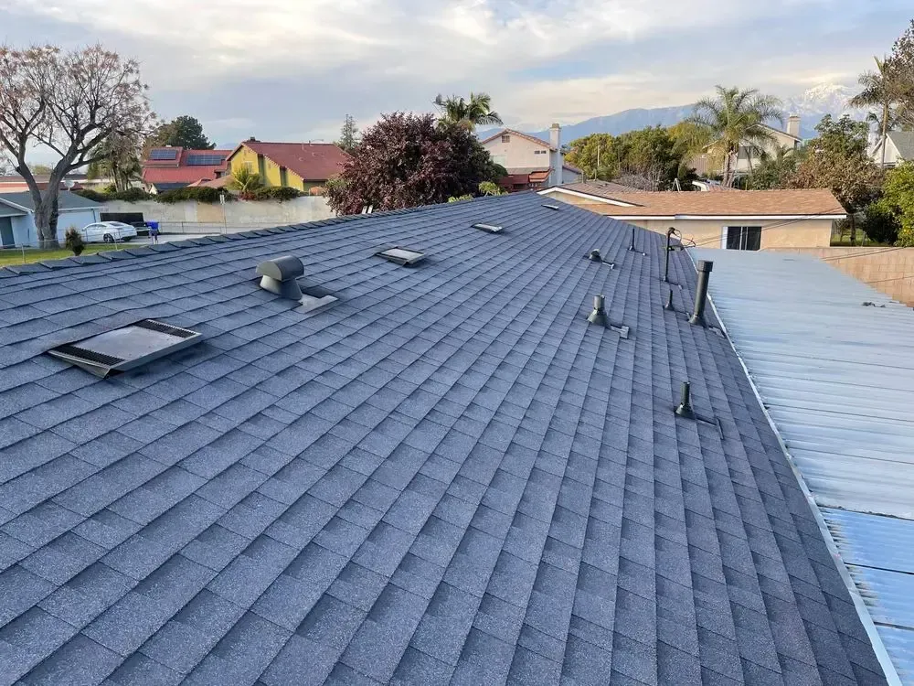 A roof with a lot of shingles and skylights on it.