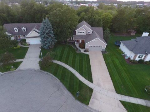 An aerial view of a house with a lush green lawn