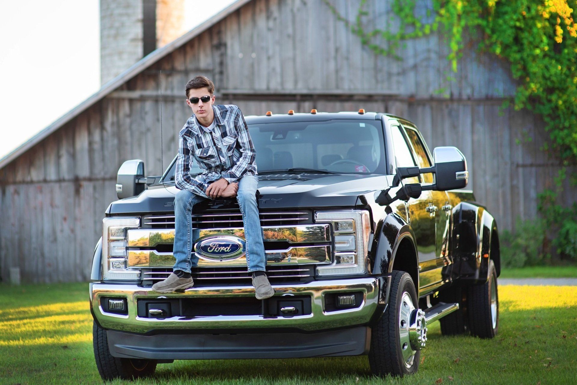 A man is sitting on the front of a truck.