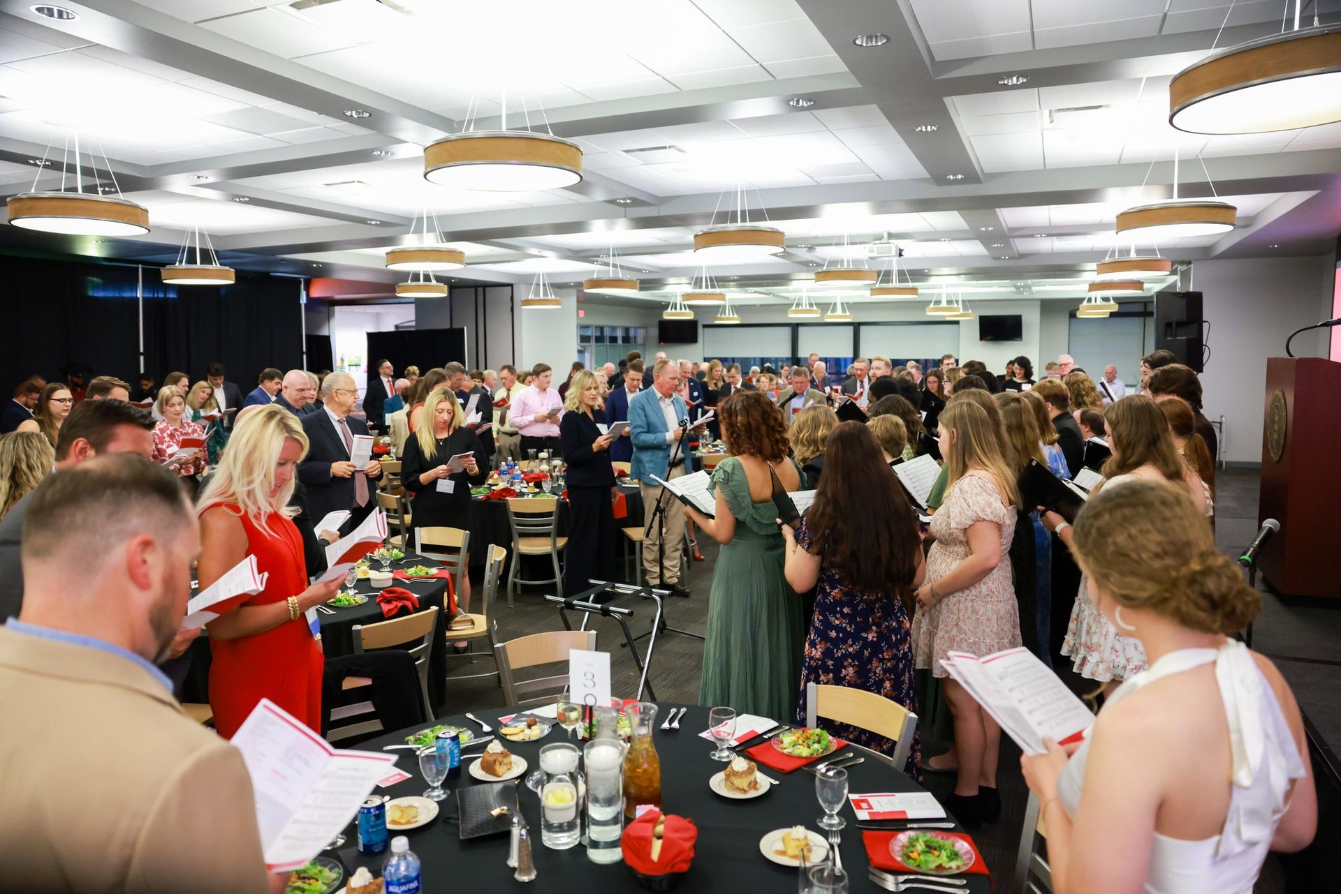A large group of people are sitting at tables in a large room.