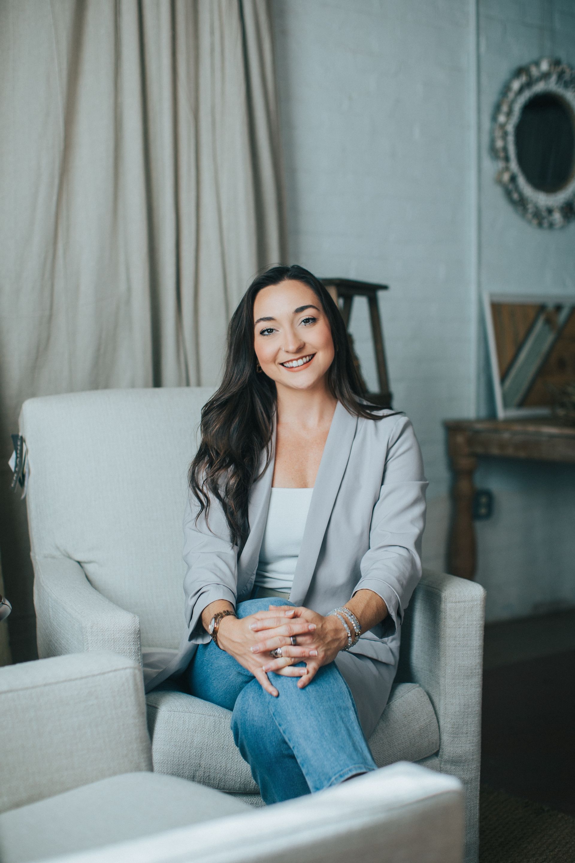 A woman is sitting in a chair with her arms crossed.