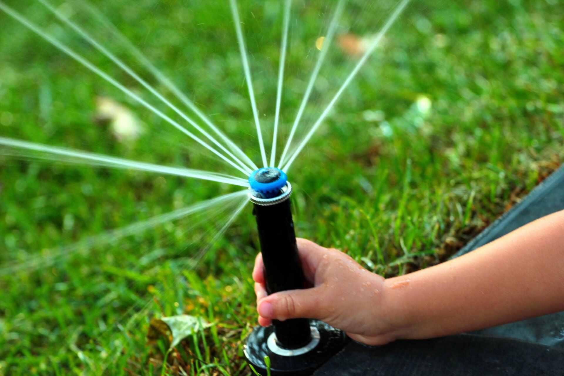 Person Adjusting Sprinkler Head — Chattanooga, TN — Coddington Enterprise