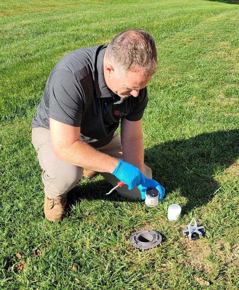 A man is kneeling down in front of a white truck.