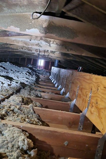 There is a lot of insulation in the attic of a house.