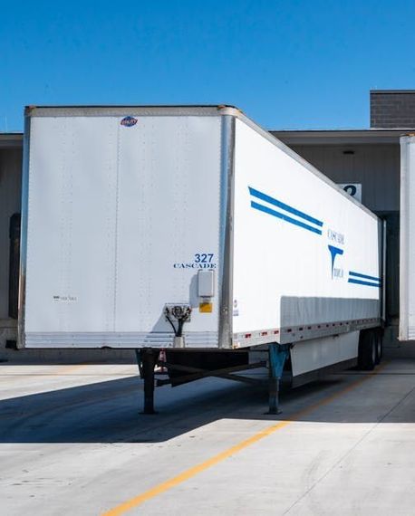 A white semi truck is parked in a parking lot