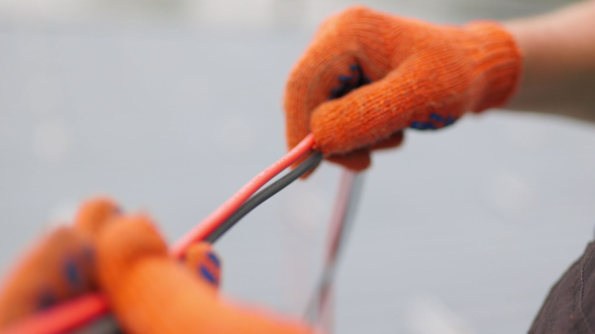 Expert residential electrical contractor installing high-quality red and black wiring safely.