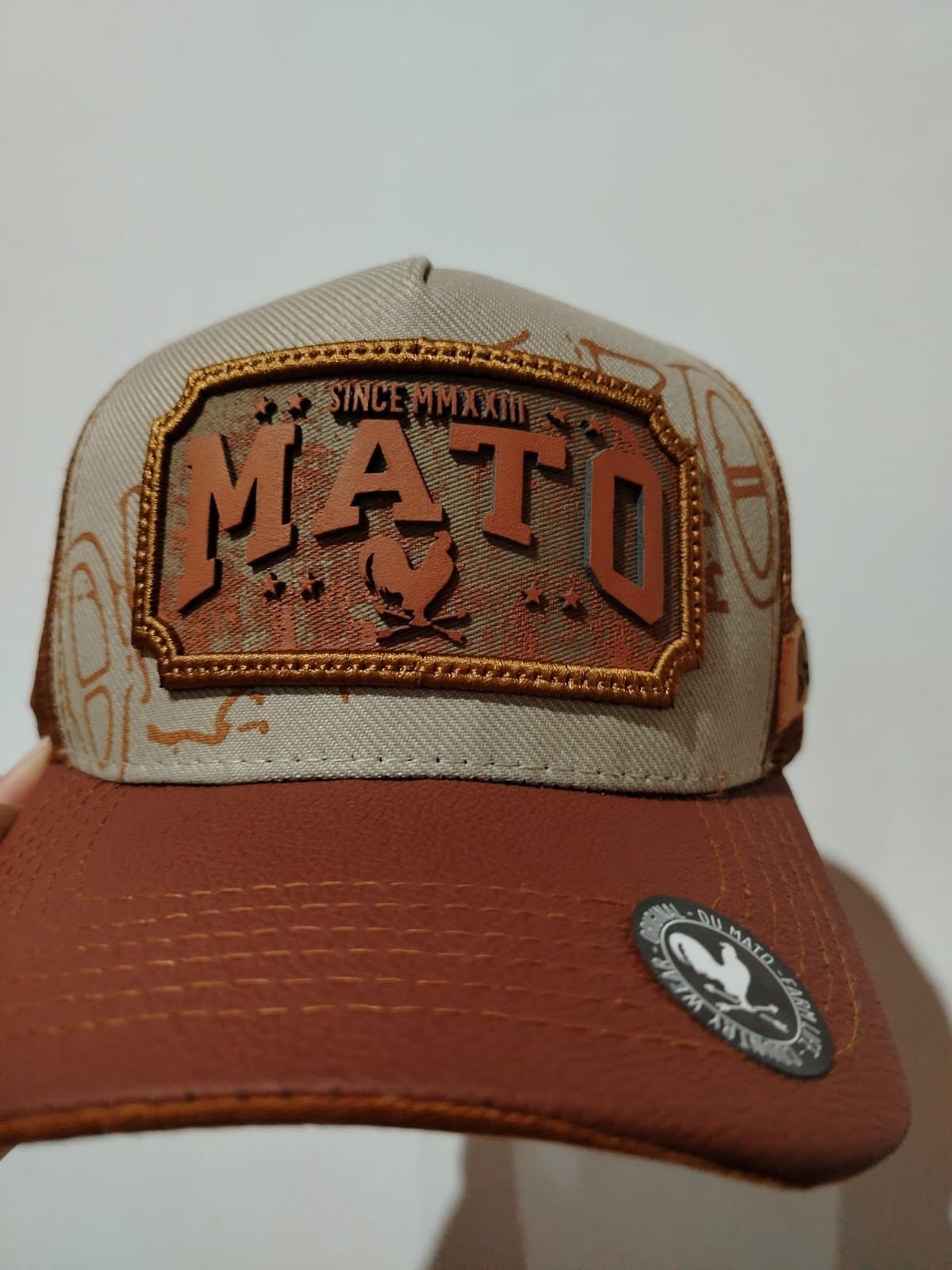 Gorra de camionero marrón y canela con la inscripción "MATO"
