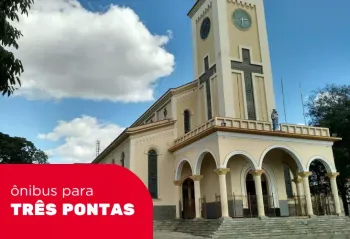 Uma igreja com uma torre do relógio e uma cruz nela, na cidade de Três Pontas
