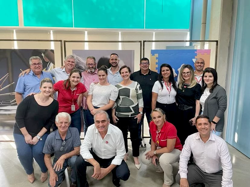 Um grupo de pessoas está posando para uma foto em uma sala.