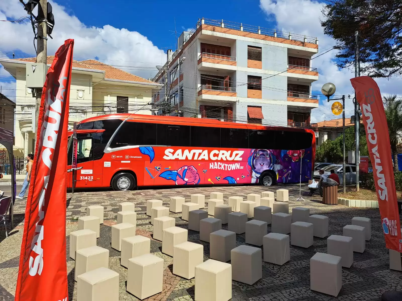 Um ônibus vermelho de santa cruz está estacionado em frente a um prédio.