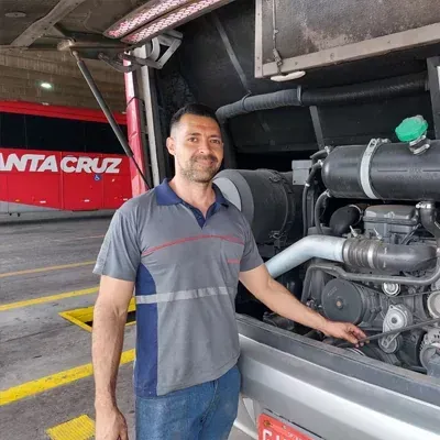 Um homem está parado na frente de um ônibus de Santa Cruz