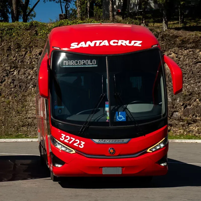 Um ônibus vermelho de Santa Cruz está estacionado na beira da estrada