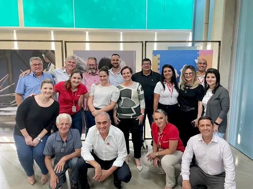 Um grupo de pessoas está posando para uma foto em uma sala.