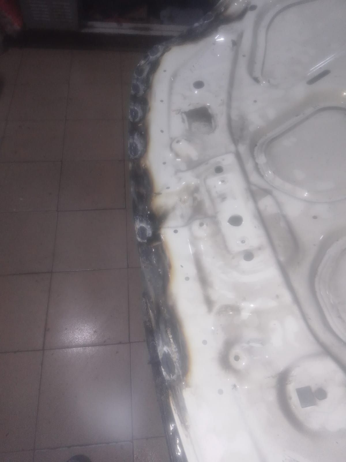 Capota de coche de color blanco con sección soldada, ambientada en interior.