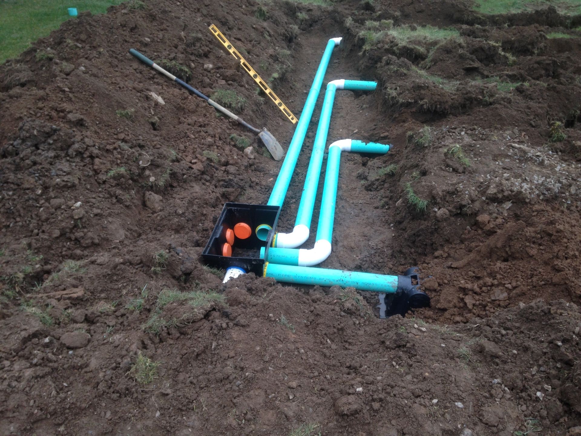 Woman in straw hat smiles, holding wine glass near a lake.