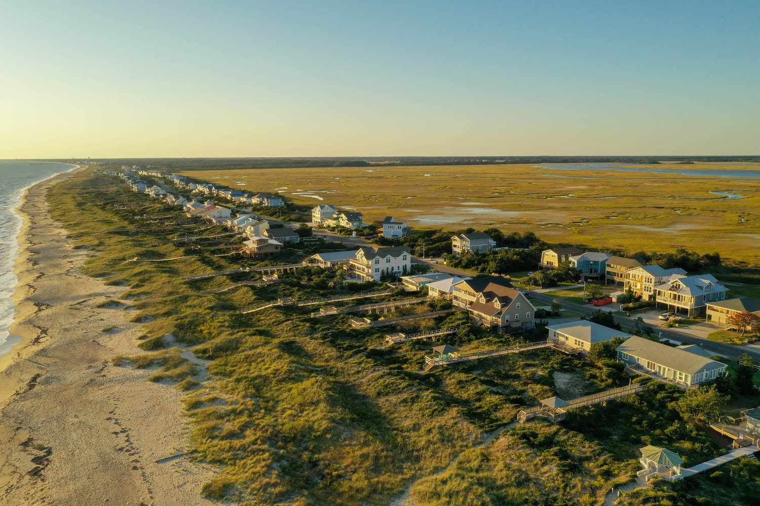 An aerial view of a residential area on the shore of a beach.